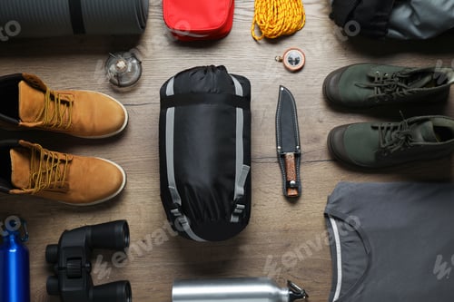 Preview: Flat lay composition with different camping equipment on wooden background
