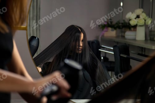 Preview: Hairdresser using black hair dryer and comb in salon for hairstyle perfect woman
