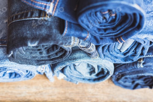 Preview: Jeans stacked on a wooden background