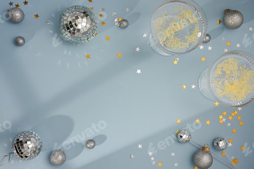 Preview: Champagne glasses and disco balls with confetti on blue background