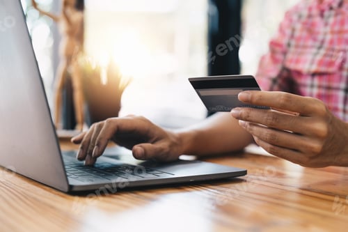 Preview: Close up young woman holding credit card and using laptop computer for online shopping. Online
