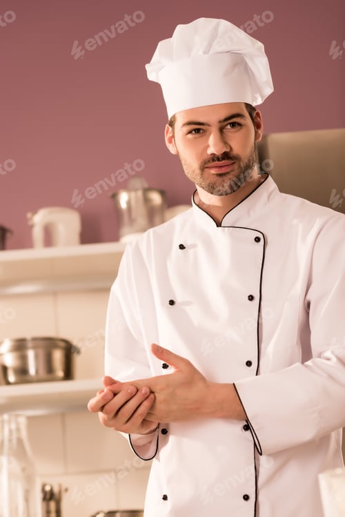 Preview: portrait of handsome confectioner in chef hat in restaurant kitchen
