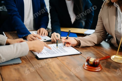 Preview: Business and lawyers discussing contract papers with brass scale on desk in office. Law,