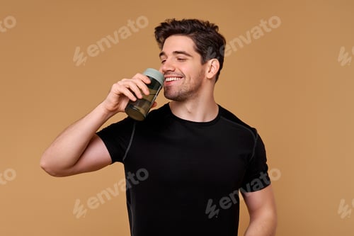 Preview: Young Man Drinks Water from Bottle in Studio