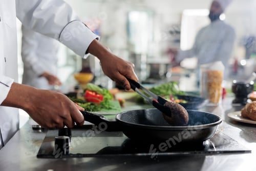Preview: Gastronomy expert cooking succulent beef patty in hot pan while cooking gourmet dish for dinner
