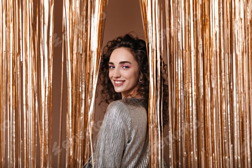 Preview: Nice lady in silver outfit smiling on gold background