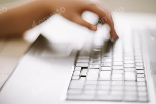 Preview: Close-up of male hands typing on laptop keyboard indoors. Businessman working in office or student