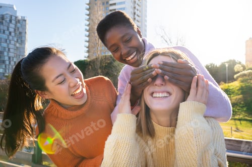 Preview: Three female friends having fun together laughing outdoors.