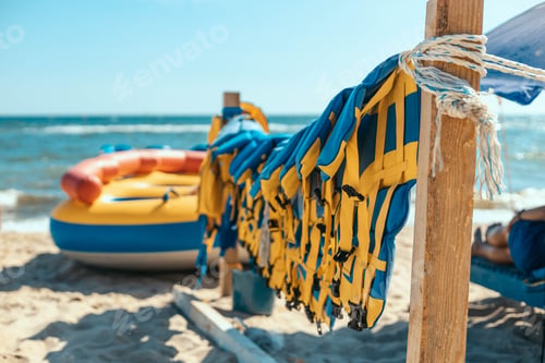 Preview: many colorful yellow blue life jacket or life vest hanging on a clothesline