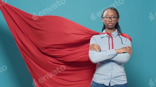 Preview: Woman superhero posing with arms crossed in studio
