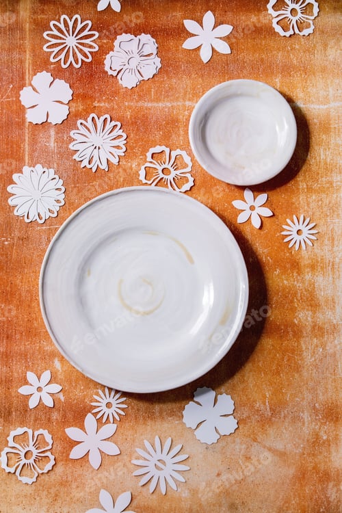 Preview: Empty white plates with paper flowers around