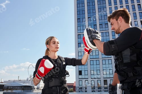 Preview: close up portrait of a attractive fit girl with red boxing gloves outdoors