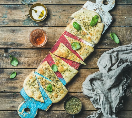 Preview: Focaccia with basil leaves, olive oil, wine on colorful board