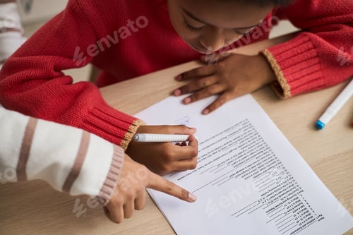 Preview: Young Black Girl Completing Worksheet with Adult Guiding Her Hand