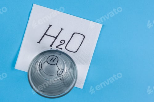 Preview: Glass with water, napkin with water formula, blue background.