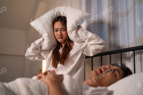 Preview: Asian woman feel frustrated from husband snoring while sleep at night.