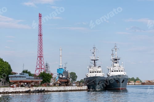 Preview: Large iron navy ships in shipyard for repair. Big crane in dockyard. Blue sea harbor