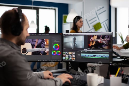 Preview: Video maker listening music at headphones while editing movie
