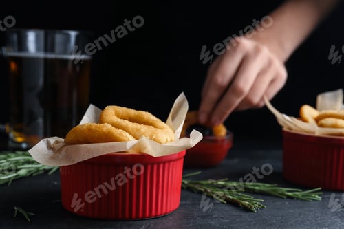 Preview: Fried onion rings served on black table in pub