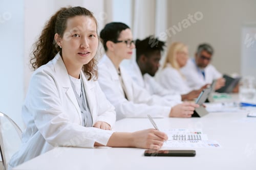 Preview: Portrait of Young Adult Asian Woman Working with Diverse Medical Team in Office