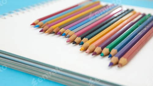 Preview: Colorful pencils on a blank notebook