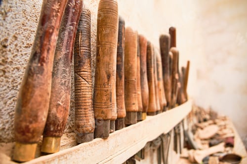 Preview: detail of the handles of tools for carving wood from a craft carpentry workshop hanging on the wall