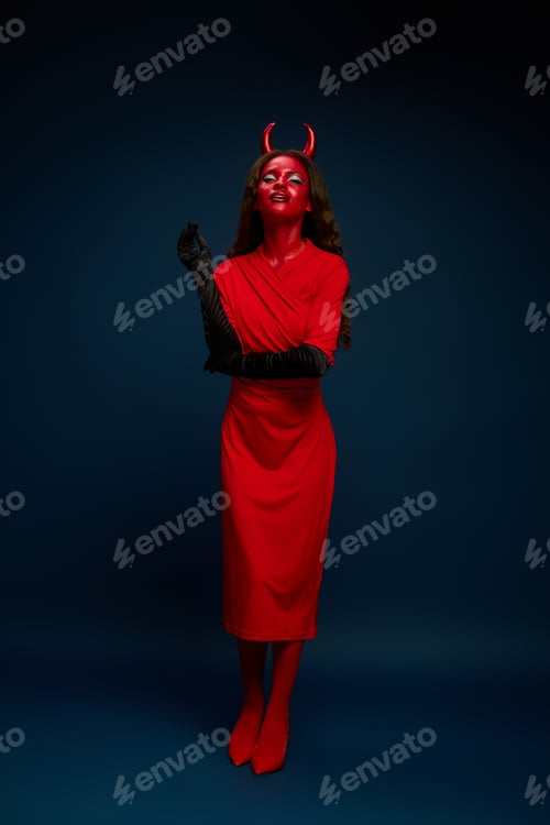 Preview: A captivating woman in a striking red Halloween costume poses alluringly against a dark backdrop