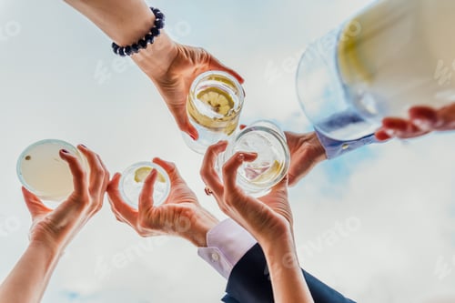 Visualização: Grupo de pessoas comemorando o sucesso com bebidas oferecendo suas bebidas.