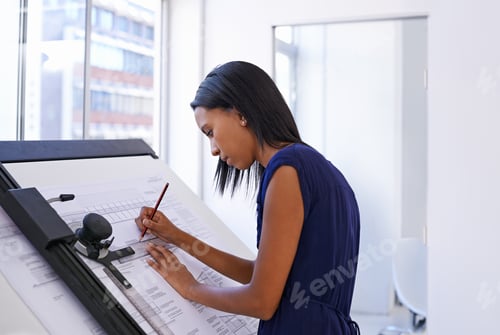 Preview: Cropped shot of an attractive female architect working at a drawing board