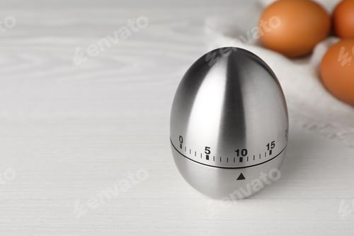 Preview: Kitchen timer and eggs on white wooden table. Space for text