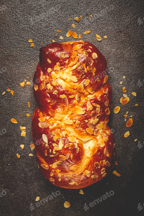 Preview: braided, sweet bread pie, with sliced almonds, braided bread, brioche, on a dark background,