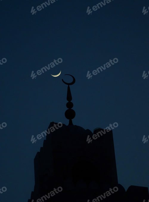 Preview: Crescent moon in a dark night sky symmetrically aligned with mosque minaret moon symbol