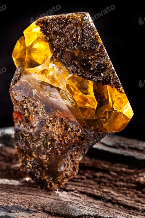 Preview: Natural amber stone. A piece of dirty amber with transparent yellow layer on piece of stoned wood