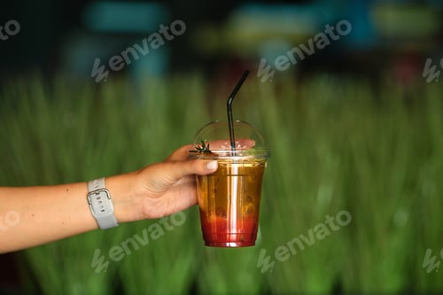 Preview: Hand with espresso tonic iced drink in take away cup