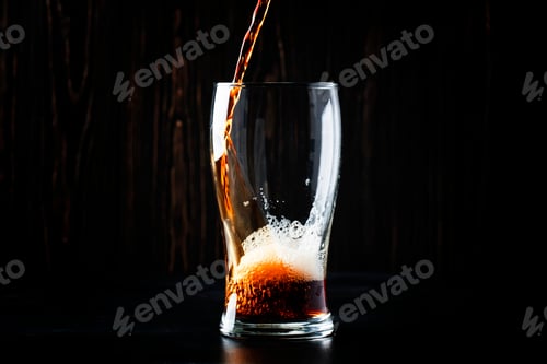 Preview: Dark english beer, ale or stout is poured into glass