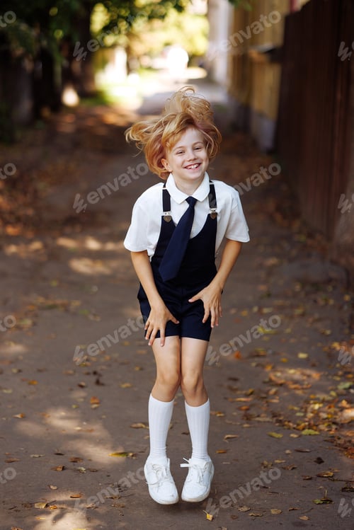 Visualização: Jovem estudante em uniforme escolar em pé na calçada. De volta à escola.