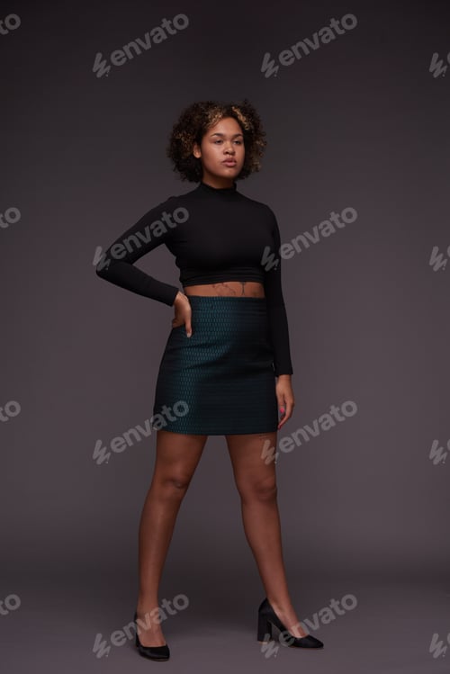 Preview: Young multi-ethnic woman in elegant casualwear standing against grey background