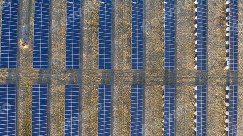 Preview: Aerial shot of solar panels in lines in the natural landscape