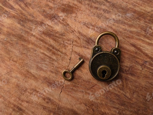 Preview: Bronze vintage padlock and a key on a wooden surface background with copy space