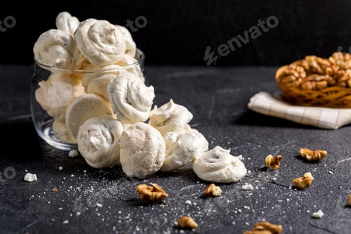 Preview: Small white meringues on a dark background