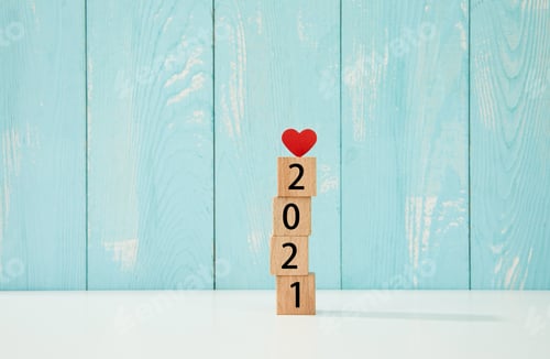 Preview: New year concept - 2021 on wooden cubes with a heart on top on a blue background