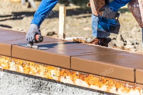 Preview: Construction Worker Using Trowel On Wet Cement Forming Coping Around New Pool