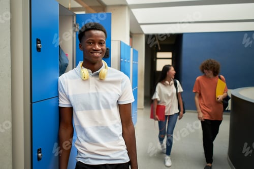 Preview: Portrait of a black student boy looking at smiling camera at school.