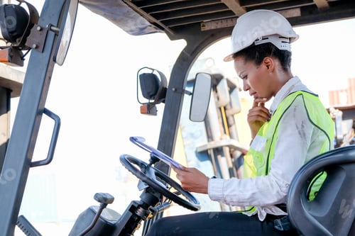 Preview: African American factory worker woman stay on tractor and look to document
