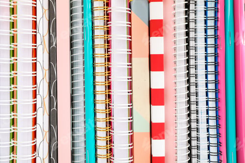 Preview: Stack of colorful books and copybooks as background, closeup