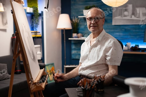 Preview: Portrait of caucasian elder artist sitting in artwork studio