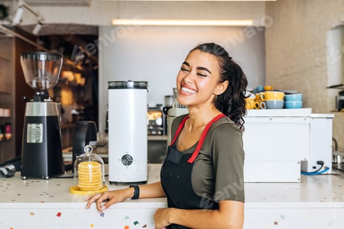 Preview: Smiling barista standing at counter in coffee shop