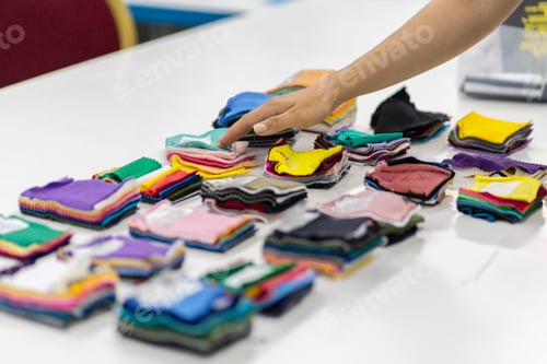 Preview: a tailor choose fabric color from samples on the table