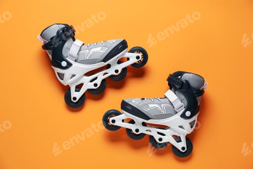 Preview: Pair of roller skates on orange background, top view