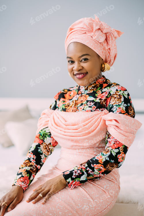 Preview: Portrait of gorgeous afro american woman with fashion makeup and jewerly, wearing ethnic pink dress